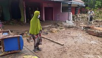 Warga Tambak Aji, Semarang, berjalan hati-hati di atas jalanan berlumpur sisa banjir semalam, Senin (7/11/2022). Foto: Afzal Nur Iman/detikJateng