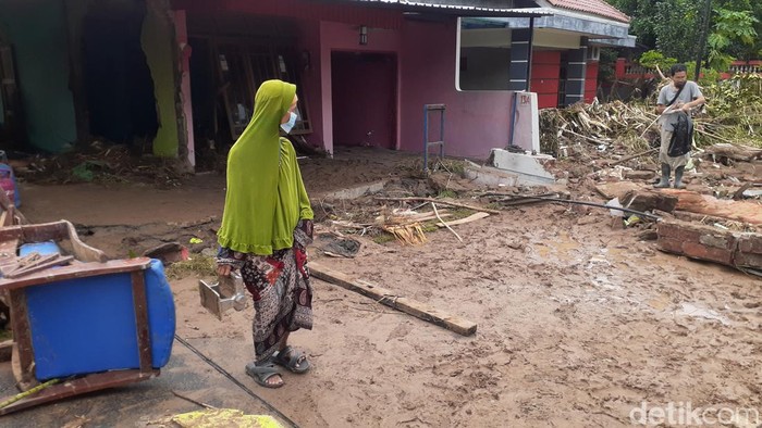 Banjir Warga Tambak Aji Semarang berjalan hati-hati di atas jalanan berlumpur sisa banjir semalam.