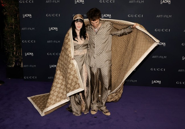 Billie Eilish dan Jesse Rutherford tampil matching dalam balutan piyama Gucci. Keduanya pun muncul di depan para juru foto dengan memakai selimut Gucci. Foto: FilmMagic/Steve Granitz via Getty Images