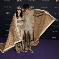 Billie Eilish dan Jesse Rutherford tampil matching dalam balutan piyama Gucci. Keduanya pun muncul di depan para juru foto dengan memakai selimut Gucci. Foto: FilmMagic/Steve Granitz via Getty Images