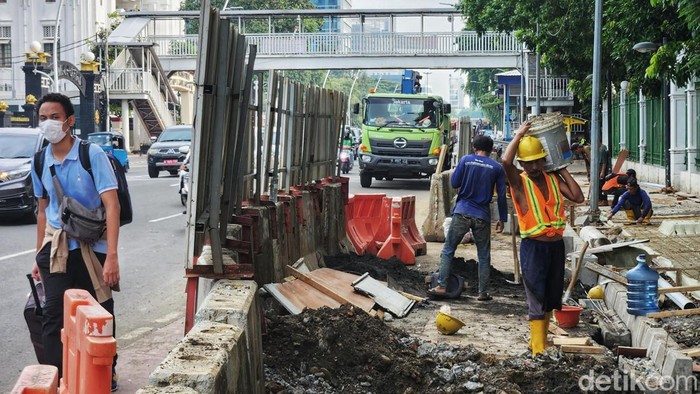 Harap Bersabar, Trotoar dan Saluran Air di Jl Medan Merdeka Timur Tengah Diperbaiki Proyek revitalisasi trotoar dan saluran air di Jl Medan Merdeka Timur, Gambir, Jakarta Pusat, tengah dikebut, Senin (7/11/2022). Begini progresnya.