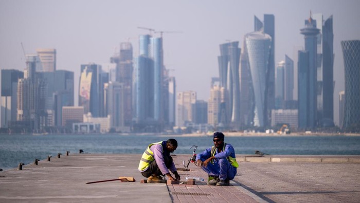 TOPSHOT - Labourers work near the FIFA World Cup countdown clock in Doha on October 25, 2022, ahead of the Qatar 2022 FIFA World Cup football tournament. (Photo by Jewel SAMAD / AFP) (Photo by JEWEL SAMAD/AFP via Getty Images)