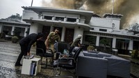 Sejumlah aparatur sipil negara mengevakuasi barang-barang dari gedung yang terbakar.
