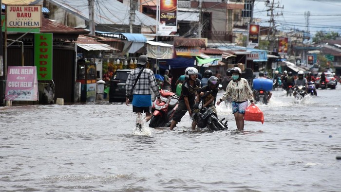 Motor-motor Mogok Gegara Terobos Banjir di Singkawang Sejumlah pengendara motor dan warga berjalan melintasi banjir di Kota Singkawang, Kalimantan Barat, Minggu (6/11/2022). Banjir setinggi 10 cm hingga 90 cm menggenangi sejumlah ruas jalan, permukiman penduduk dan fasilitas umum di Kota Singkawang akibat tingginya curah hujan sejak Sabtu (5/11/2022) malam hingga Minggu (6/11/2022) di wilayah setempat. ANTARA FOTO/Reza Novriandi/jhw/wsj.