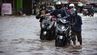 Tampak sejumlah pengendara mendorong motornya yang mogok akibat nekat menerjang banjir.  