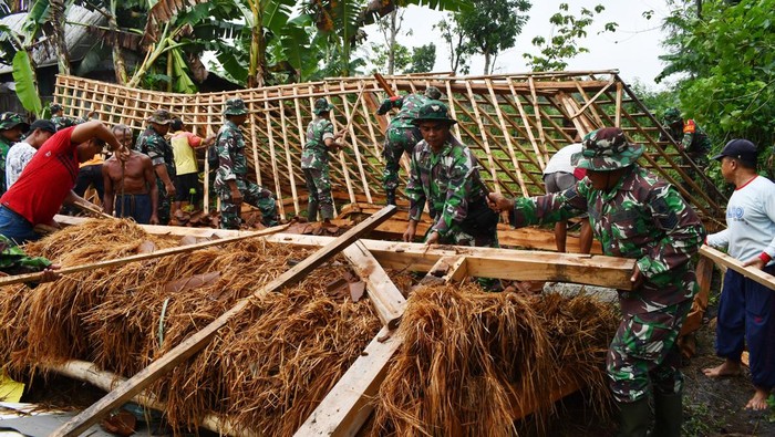 Sejumlah prajurit TNI dan relawan membersihkan pohon tumbang yang menimpa rumah warga akibat terjangan angin kencang di Desa Dawuhan, Pilangkenceng, Kabupaten Madiun, Jawa Timur, Senin (7/11/2022). Hujan deras disertai angin kencang pada Minggu (6/11) mengakibatkan sebuah rumah rusak berat dan puluhan lainnya rusak serta puluhan pohon tumbang. ANTARA FOTO/Siswowidodo/wsj.