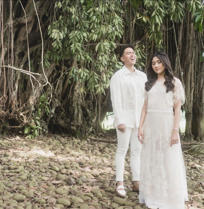 Erina Gudono tampil feminin berbalut gaun putih rancangan desainer Biyan Wanaatmadja. Gaun berpotongan simpel ini tampak mewah berkat detail lace dan bordiran. Foto: Instagram/@kaesangp @erinagudono