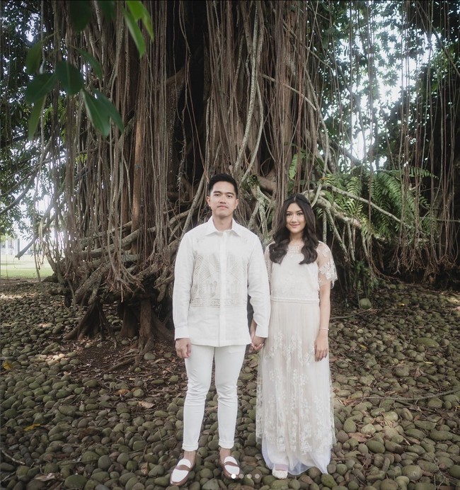 Dalam tema pemotretan prewedding lainnya, dua sejoli ini kompak memakai busana serba putih. Kali ini mereka pose dengan latar pohon beringin. Foto: Instagram/@kaesangp @erinagudono