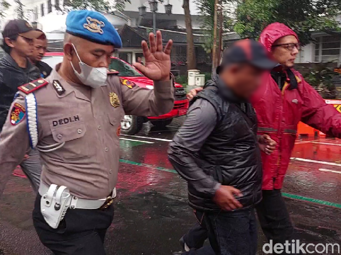 Pria berompi hitam yang diamankan petugas saat kebakaran melanda Balai Kota Bandung