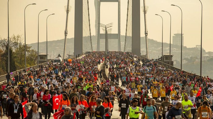 Ribuan Pelari Ikut Maraton Lintas Benua di Turkiaine War Ikaria Angel bulk cargo ship, which departed from Ukrainian port of Chornomorsk, sails under 15th July Martyrs bridge over the Bosphorus as runners take part in a Marathon in Istanbul, Turkey, Sunday, Nov. 6, 2022. (AP Photo/Emrah Gurel)