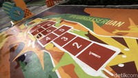 Di area tersebut terdapat mural bergambarkan permainan ular tangga.