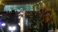 Pengendara motor yang melintas memilih untuk berhenti sejenak. Beberapa dari mereka berhenti untuk memakai jas hujan.