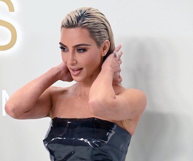 Kesan minimalis ditonjolkan Kim dengan hanya memakai cincin sebagai aksesori andalan. Gayanya kian sempurna dangan rambut wet-look yang sleek. (Foto: AFP via Getty Images/ANDREA RENAULT)
