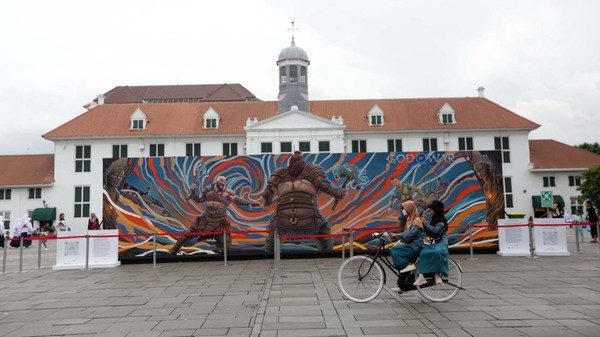 Warga dengan bersepeda melintas di depan mural tersebut.