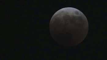 Dikenal sebagai blood moon, bulan tampak berwarna jingga kemerahan. AP Photo/Rick Rycroft.