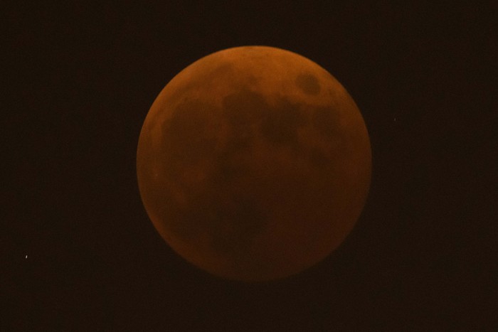 The moon rises behind a corner tower along the outer walls of the Forbidden City during a lunar eclipse in Beijing, Tuesday, Nov. 8, 2022. (AP Photo/Mark Schiefelbein)