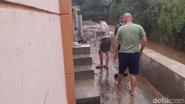 Warga Cirahashas, Bandung Barat membersihkan sisa banjir.