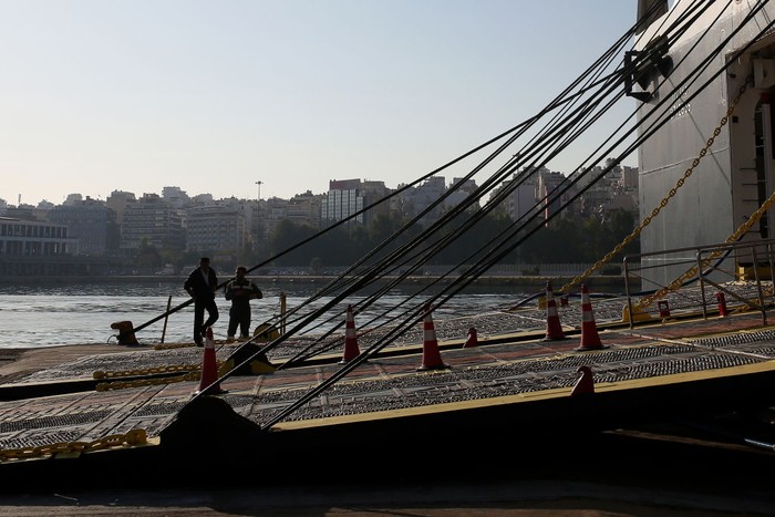 1244631197 PIRAEUS, GREECE - NOVEMBER 9: A woman walks next to moored passenger ferries during a 24-hour general strike at the port of Piraeus, Greece on November 9, 2022. Ferries and ships will remain docked at the port during the 24-hour strike. (Photo by Stringer/Anadolu Agency via Getty Images)