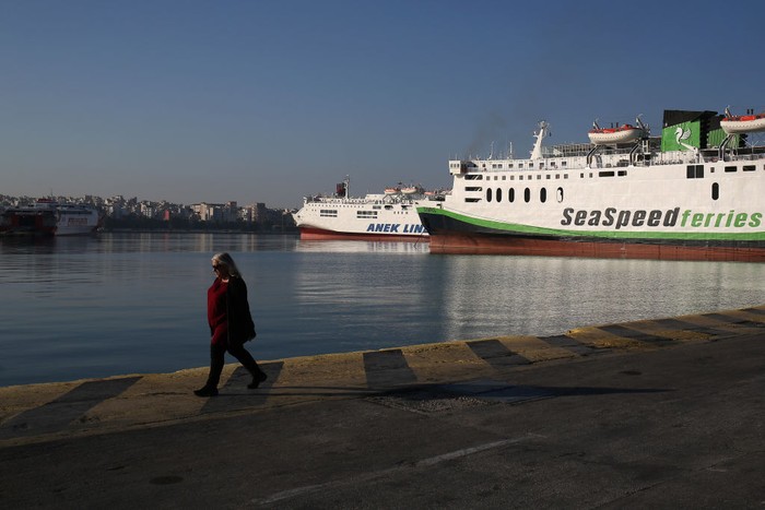 PIRAEUS, GREECE - NOVEMBER 9: A woman walks next to moored passenger ferries during a 24-hour general strike at the port of Piraeus, Greece on November 9, 2022.  Ferries and ships will remain docked at the port during the 24-hour strike. (Photo by Stringer/Anadolu Agency via Getty Images)