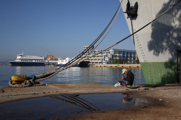 1244631197 PIRAEUS, GREECE - NOVEMBER 9: A woman walks next to moored passenger ferries during a 24-hour general strike at the port of Piraeus, Greece on November 9, 2022. Ferries and ships will remain docked at the port during the 24-hour strike. (Photo by Stringer/Anadolu Agency via Getty Images)