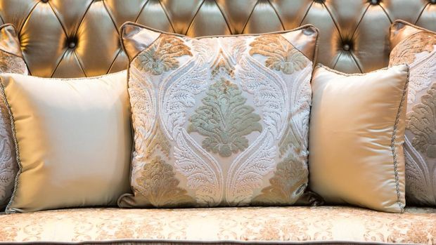 Luxury and classic style pillows on a shiny leather sofa.