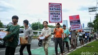 Para warga ini berjalan menuju gedung DPR dengan membawa berbagai macam tulisan.