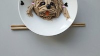 Setelah mie digunting, barulah terlihat sosok anjing malta yang menggemaskan. Lidahnya tampak keluar dan bulu anjing itu dikuncir dua.