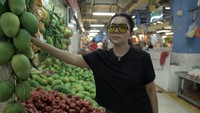Mayangsari juga mengunjungi lapak penjual buah segar. Terlihat ia membeli buah mangga, karena tertarik oleh salah satu penjual yang menggantung buahnya seperti masih di atas pohon. Foto: YouTube Mayangsari Channel