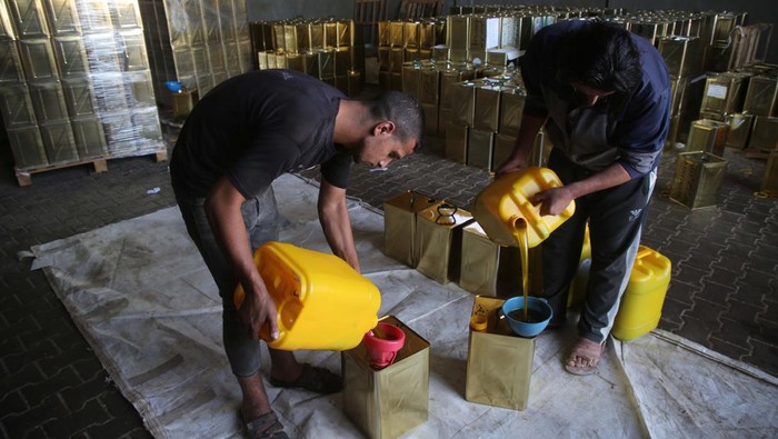 Palestinian workers are seen hand filtering olive oil in Khan Yunis, Gaza Strip on November 07, 2022. Olive oil produced in the Gaza Strip is exported to Arab countries.  (Photo by Majdi Fathi/NurPhoto via Getty Images)