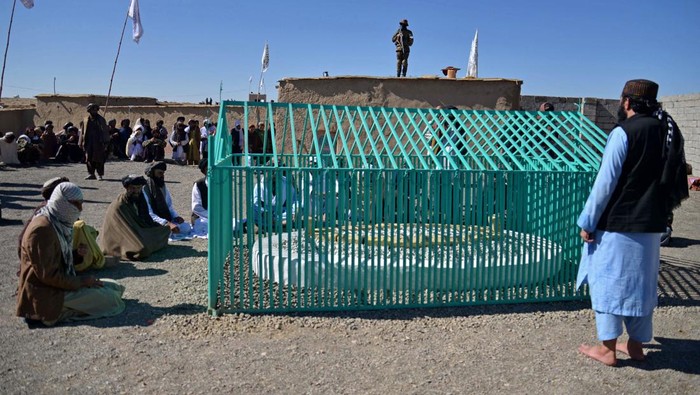 TOPSHOT - Members of the Taliban sit next to the tomb of late Afghan Taliban leader Mullah Omar, at Omarzo in Suri district of Zabul province on November 7, 2022. - The Taliban on November 6 revealed the final resting place of the movement's founder, Mullah Omar, whose death and burial they kept secret for years. Rumours surrounding Omar's health and whereabouts circulated for years after the Taliban were kicked out of power in 2001 by a US-led invasion, and they only admitted in April 2015 that he had died two years earlier. (Photo by AFP) (Photo by -/AFP via Getty Images)