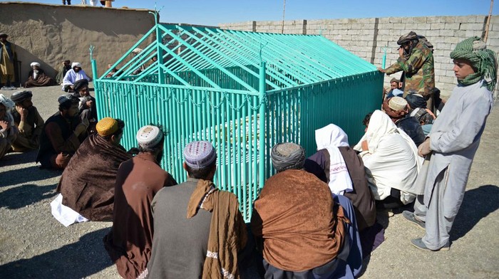 Penampakan Makam Pendiri Taliban Usai 9 Tahun Disembunyikan TOPSHOT - Members of the Taliban sit next to the tomb of late Afghan Taliban leader Mullah Omar, at Omarzo in Suri district of Zabul province on November 7, 2022. - The Taliban on November 6 revealed the final resting place of the movement's founder, Mullah Omar, whose death and burial they kept secret for years. Rumours surrounding Omar's health and whereabouts circulated for years after the Taliban were kicked out of power in 2001 by a US-led invasion, and they only admitted in April 2015 that he had died two years earlier. (Photo by AFP) (Photo by -/AFP via Getty Images)