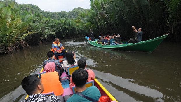 Pengunjung menyusuri sungai dengan perahu menuju desa wisata di kawasan pegunungan Karst Rammang-Rammang di Kabupaten Maros, Sulawesi Selatan, Selasa (8/11/2022). Pengunjung dapat menyewa perahu dengan biaya Rp200 ribu hingga Rp300 ribu tergantung jumlah penumpangnya untuk menyusuri Sungai Pute menuju desa wisata Rammang-Rammang yang memiliki pemandangan alam pegunungan karst. ANTARA FOTO/Aloysius Jarot Nugroho/tom.