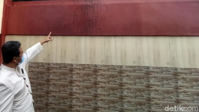 Guru menunjukkan tembok gedung SMK di Klaten yang dilempari cat, Kamis (10/11/2022).