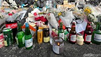 Tak sedikit orang yang meletakkan botol soju yang masih berisi. Banyak juga yang meletakkan makanan di area tragedi.