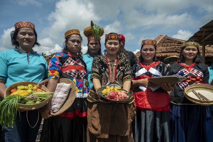 Indigenous people bring their agricultural products to the produce carnival at the opening of the Mosintuwu Festival in Tentena, Poso Regency, Central Sulawesi Province, Indonesia on November 9, 2022. After a two-year hiatus due to the COVID-19 pandemic, the cultural festival with the theme Remembering, Maintaining, and Celebrating Poso Cultural Traditions was held again and was attended by indigenous people from 20 village representatives and four local tribes, namely Pamona, Mori, Bada, and Napu. The festival, which emphasizes the participation of indigenous peoples, features a variety of cultural attractions and traditions of each tribe including its culinary peculiarities. (Photo by Basri Marzuki/NurPhoto via Getty Images)