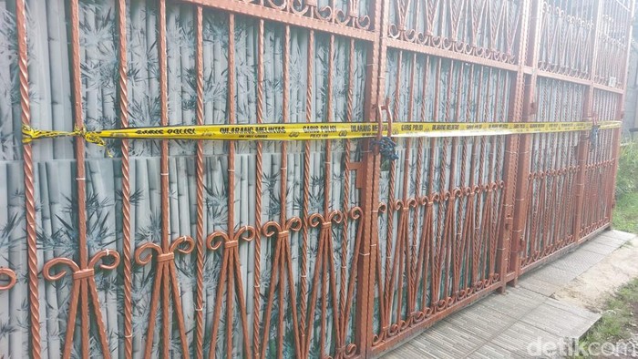 Empat jenazah yang merupakan satu keluarga ditemukan di sebuah rumah di kawasan Kalideres, Jakbar. Garis polisi tampak terpasang di pagar rumah tersebut. (Rumondang N/detikcom)