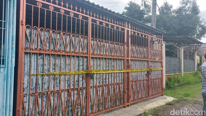 Empat jenazah yang merupakan satu keluarga ditemukan di sebuah rumah di kawasan Kalideres, Jakbar. Garis polisi tampak terpasang di pagar rumah tersebut. (Rumondang N/detikcom)