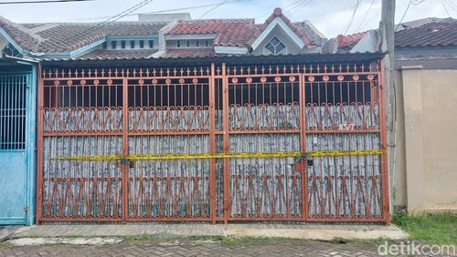 Empat jenazah yang merupakan satu keluarga ditemukan di sebuah rumah di kawasan Kalideres, Jakbar. Garis polisi tampak terpasang di pagar rumah tersebut. (Rumondang N/detikcom)
