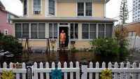 Seorang pria Dale laJeunesse berdiri di depan rumahnya yang dikelilingi oleh air banjir. (Joe Raedle/Getty Images)