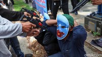 Massa menggelar teaterikal yang menggambarkan kekerasan terhadap muslim uighur.