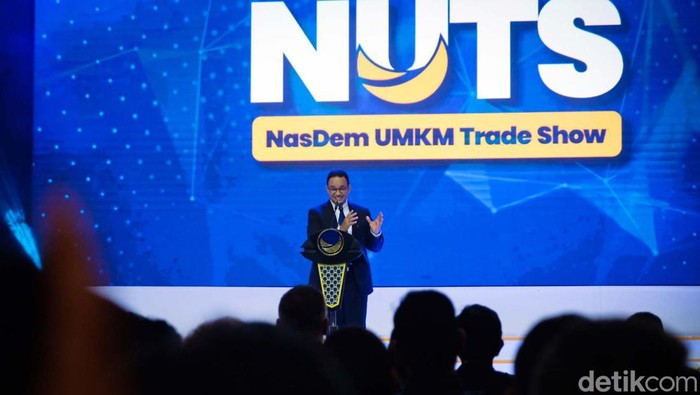 Anies Baswedan menghadiri peringatan HUT NasDem di Jakarta. Anies duduk di samping Ketum NasDem Surya Paloh dan juga mendapatkan potongan kue.