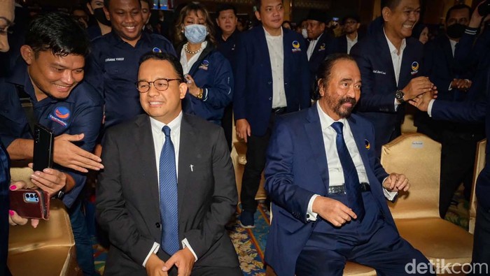Anies Baswedan menghadiri peringatan HUT NasDem di Jakarta. Anies duduk di samping Ketum NasDem Surya Paloh dan juga mendapatkan potongan kue.
