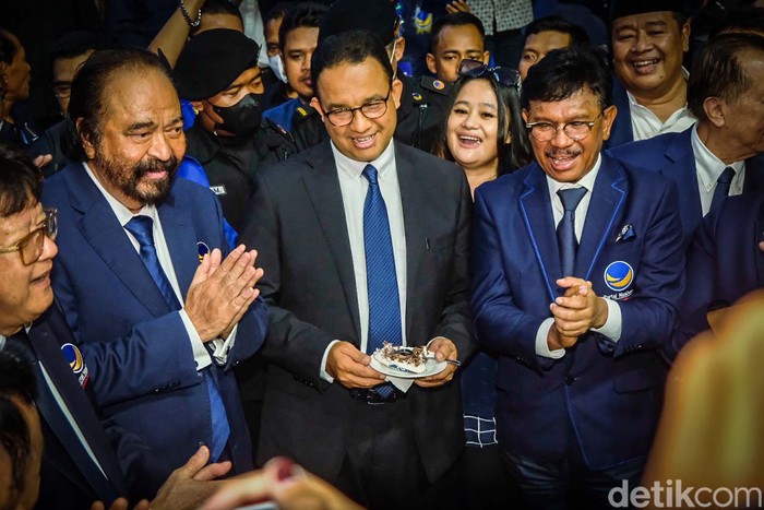 Anies Baswedan menghadiri peringatan HUT NasDem di Jakarta. Anies duduk di samping Ketum NasDem Surya Paloh dan juga mendapatkan potongan kue.