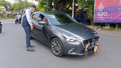 Petugas Dishub Bali memberikan imbauan untuk putar arah di Simpang Jalan Pulau Moyo, Denpasar.