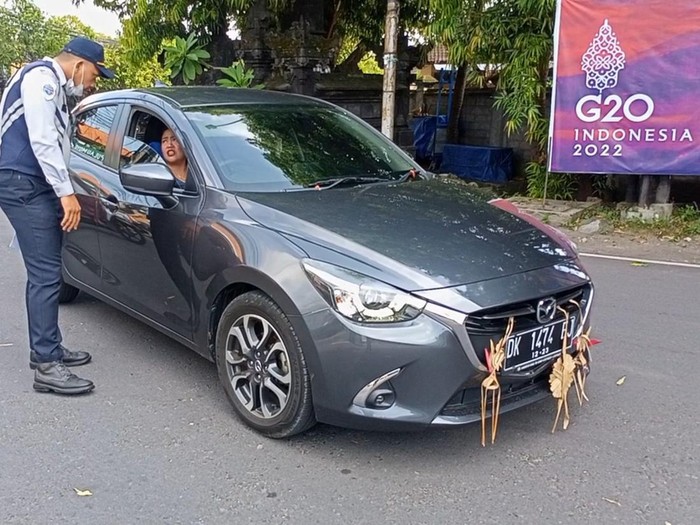 Petugas Dishub Bali memberikan imbauan untuk putar arah di Simpang Jalan Pulau Moyo, Denpasar.