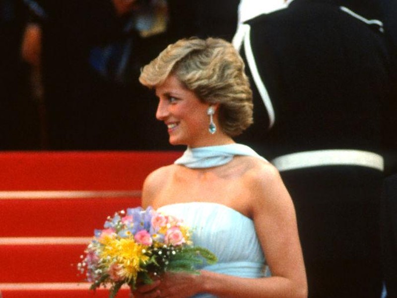 CANNES, FRANCE - MAY 15: Diana, Princess of Wales, wearing a pale blue silk chiffon strapless dress with a matching chiffon stole designed by Catherine Walker, arrives to attend a Gala night in honour of actor Sir Alec Guinness at the Cannes Film Festival on May 15, 1987 in Cannes, France. (Photo by Anwar Hussein/Getty Images)