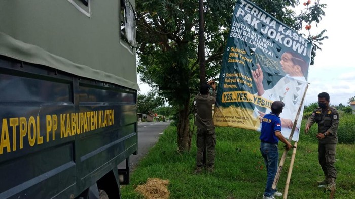 Satpol PP Pemkab Klaten mencopot baliho Terima Kasih Jokowi di Nglinggi, Klaten Selatan.