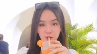 Puja Friska begitu memerhatikan kesehatan. Jus buah dan sayuran jadi minuman favoritnya. Salah satunya jus wortel yang oranye segar ini dipesan saat ia duduk di kafe yang nyaman. Foto: Instagram/hii.puja