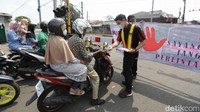 Petugas PT Kereta Commuter Indonesia (KCI) melakukan sosialisasi kepada pengguna kendaraan untuk mendahulukan kereta yang lewat.