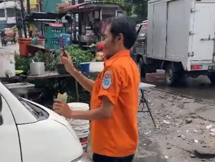 Tangkapan layar video seorang jukir memeras pemilik tanah di Medan.